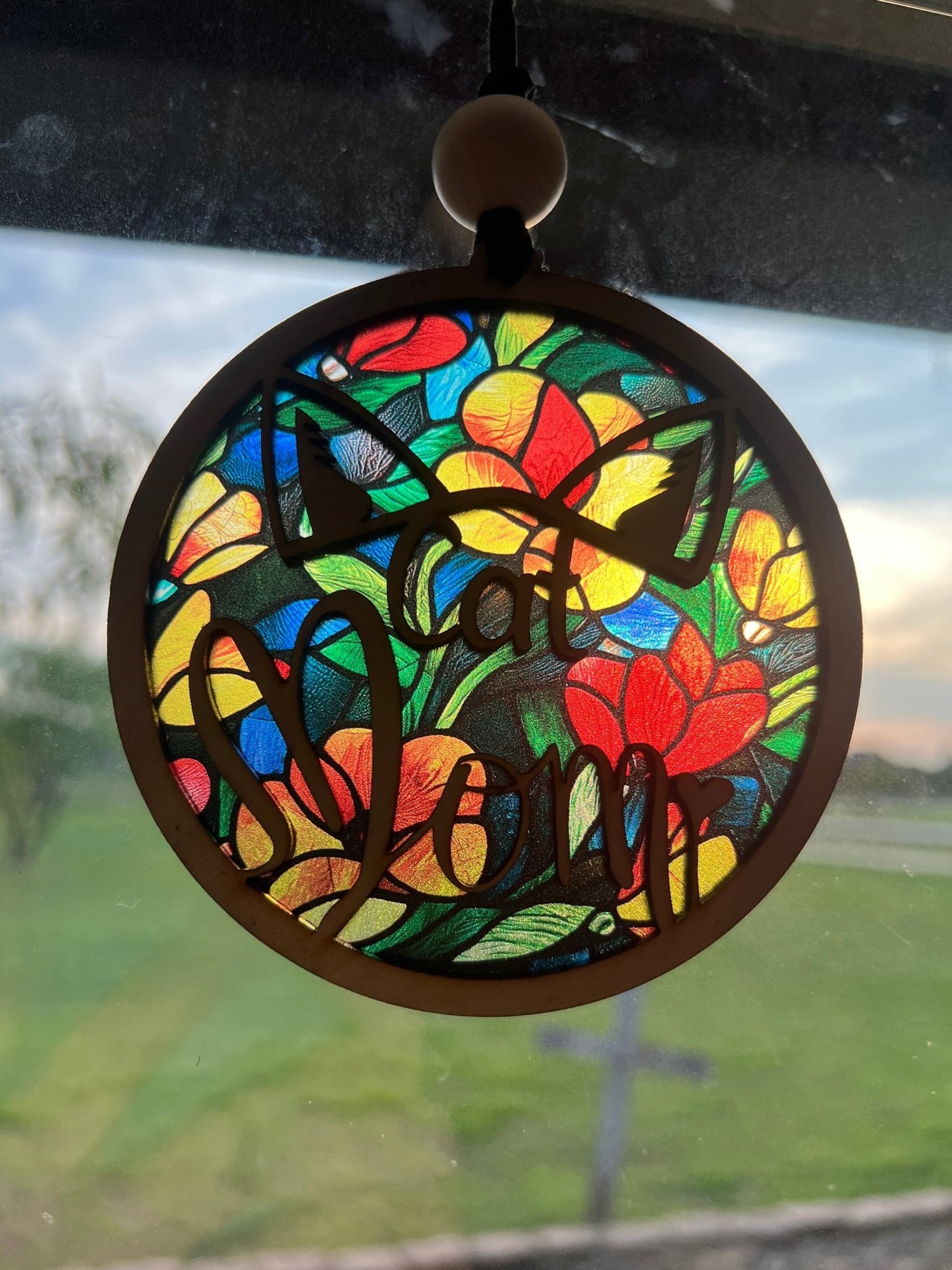Flower Cat Mom Suncatcher featuring wood and multicolor acrylic in a stained glass effect in sunlight.