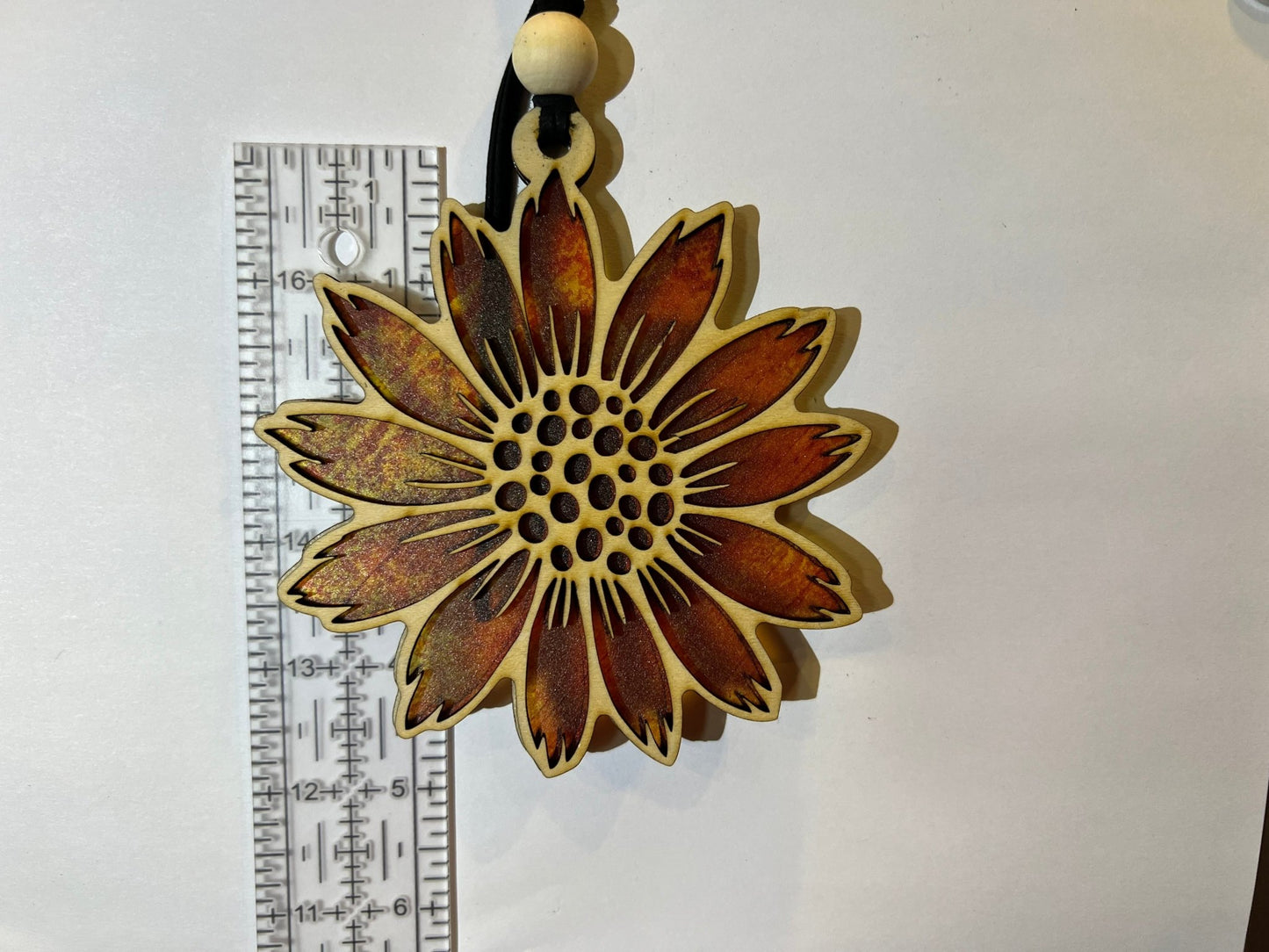 Sunflower stained glass effect suncatcher made of natural wood and acrylic on white background.