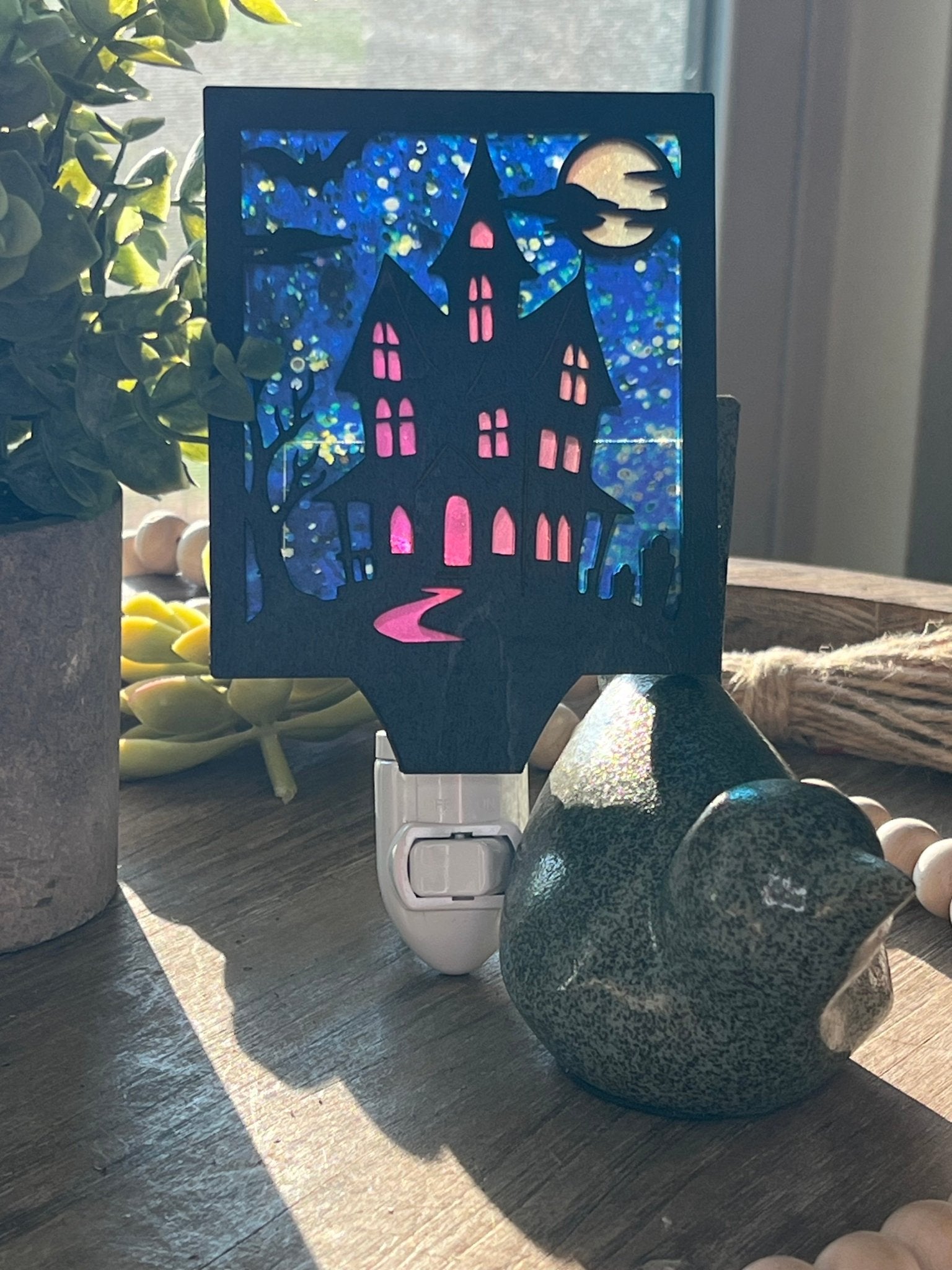 Haunted House Nightlight made of wood and acrylic, golden oak stained, rustic decor, front facing in sunlight..