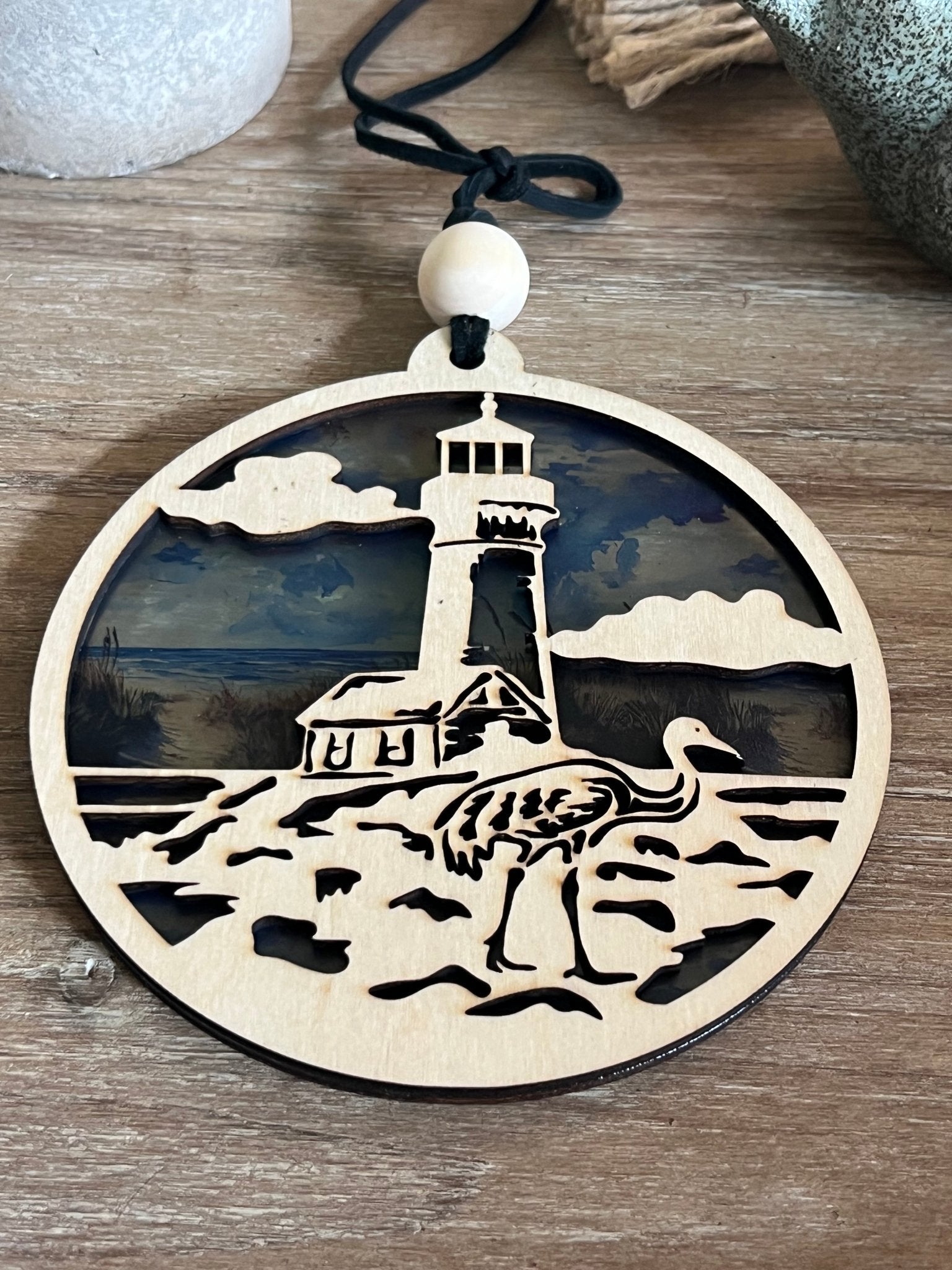 Lighthouse nightlight made of natural wood and multicolor acrylic, offering a rustic-modern feel.