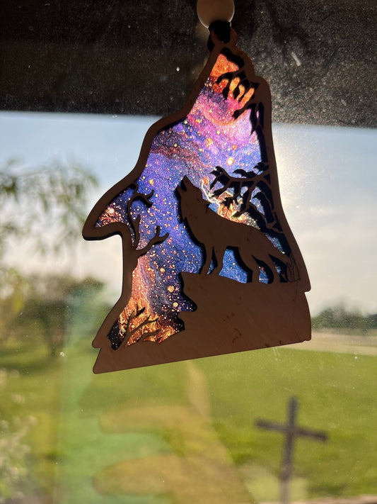 Howling Wolf Suncatcher in wood and multicolor acrylic, 4.75x3 inches in sunlight.