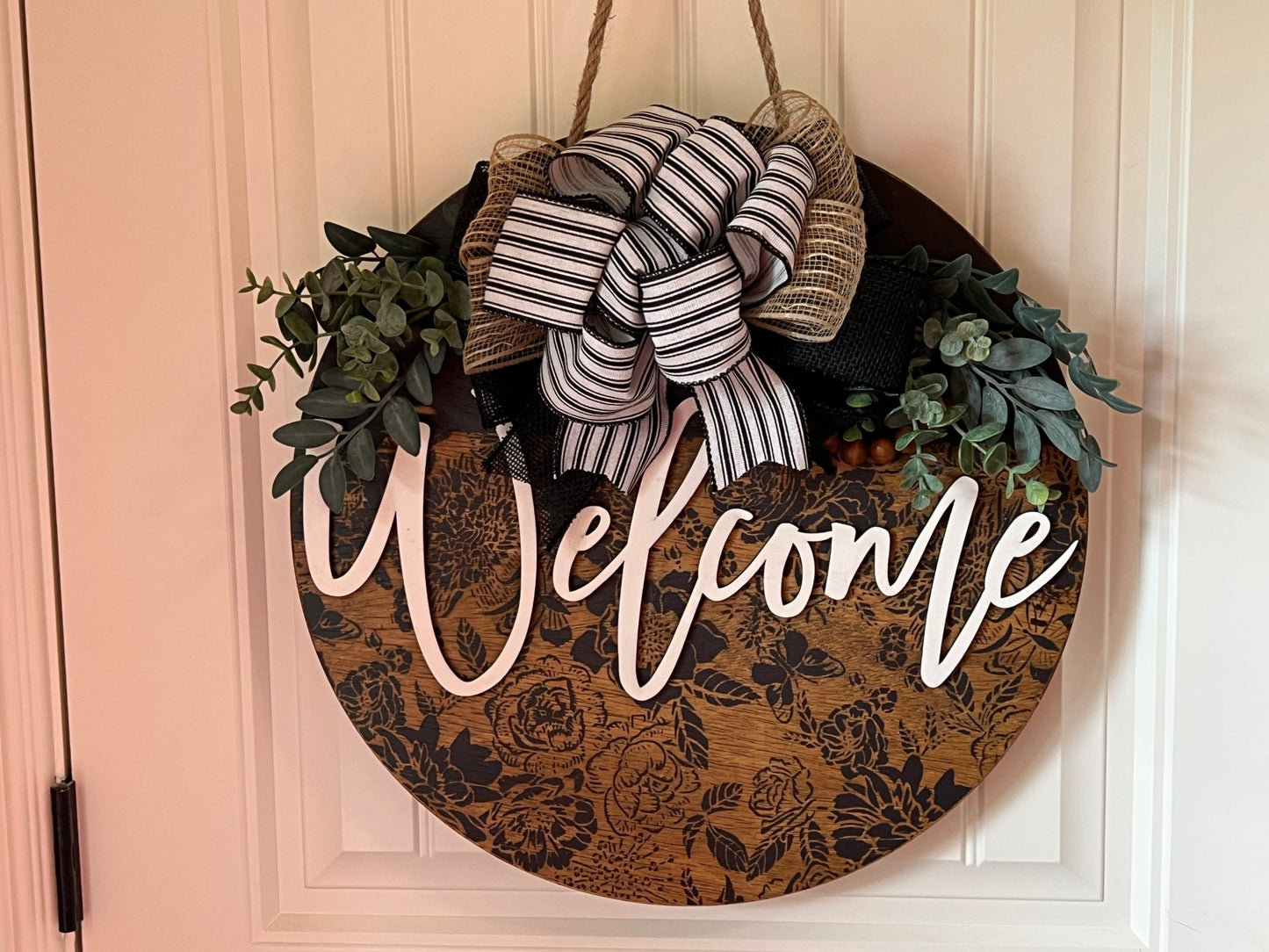 Wooden butterfly door hanger with floral design in natural wood and black accents.