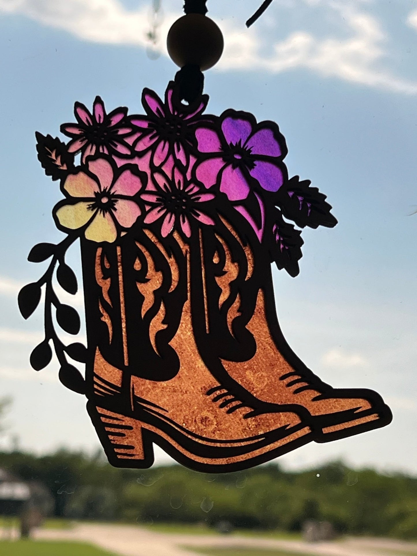 Rustic suncatcher featuring boots and flowers with stained glass effect, made of acrylic and wood in multicolor hues.