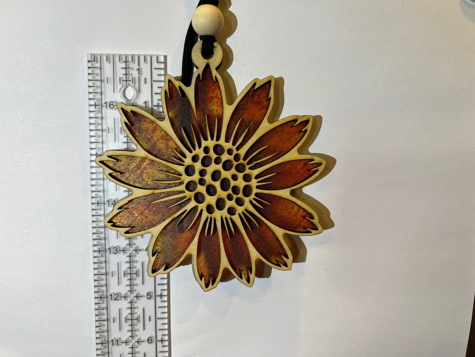 Sunflower stained glass effect suncatcher made of natural wood and acrylic on white background.