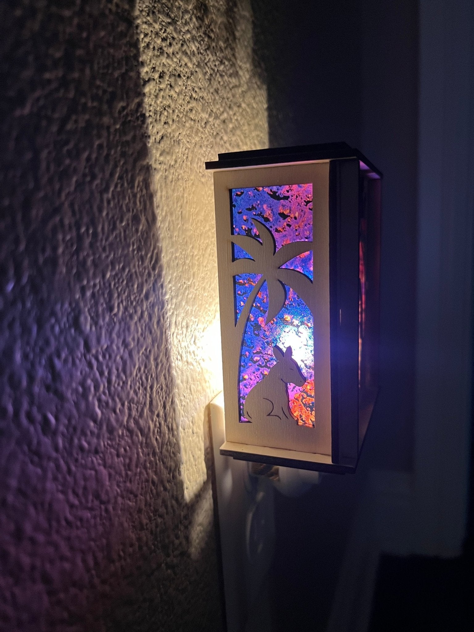 Natural wood Christmas Nativity Lantern Nightlight with multicolor designs in dark hallway left side view.
