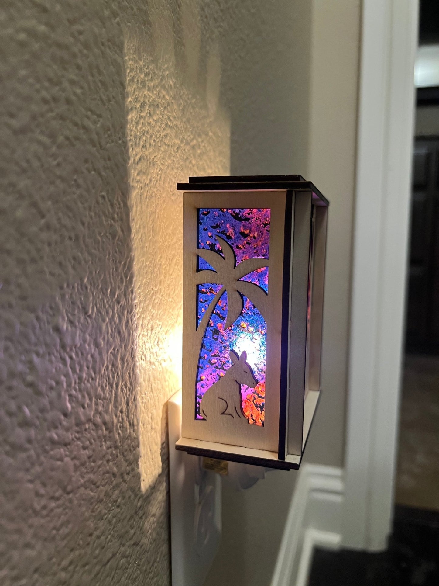 Natural wood Christmas Nativity Lantern Nightlight with multicolor designs lit with side view.