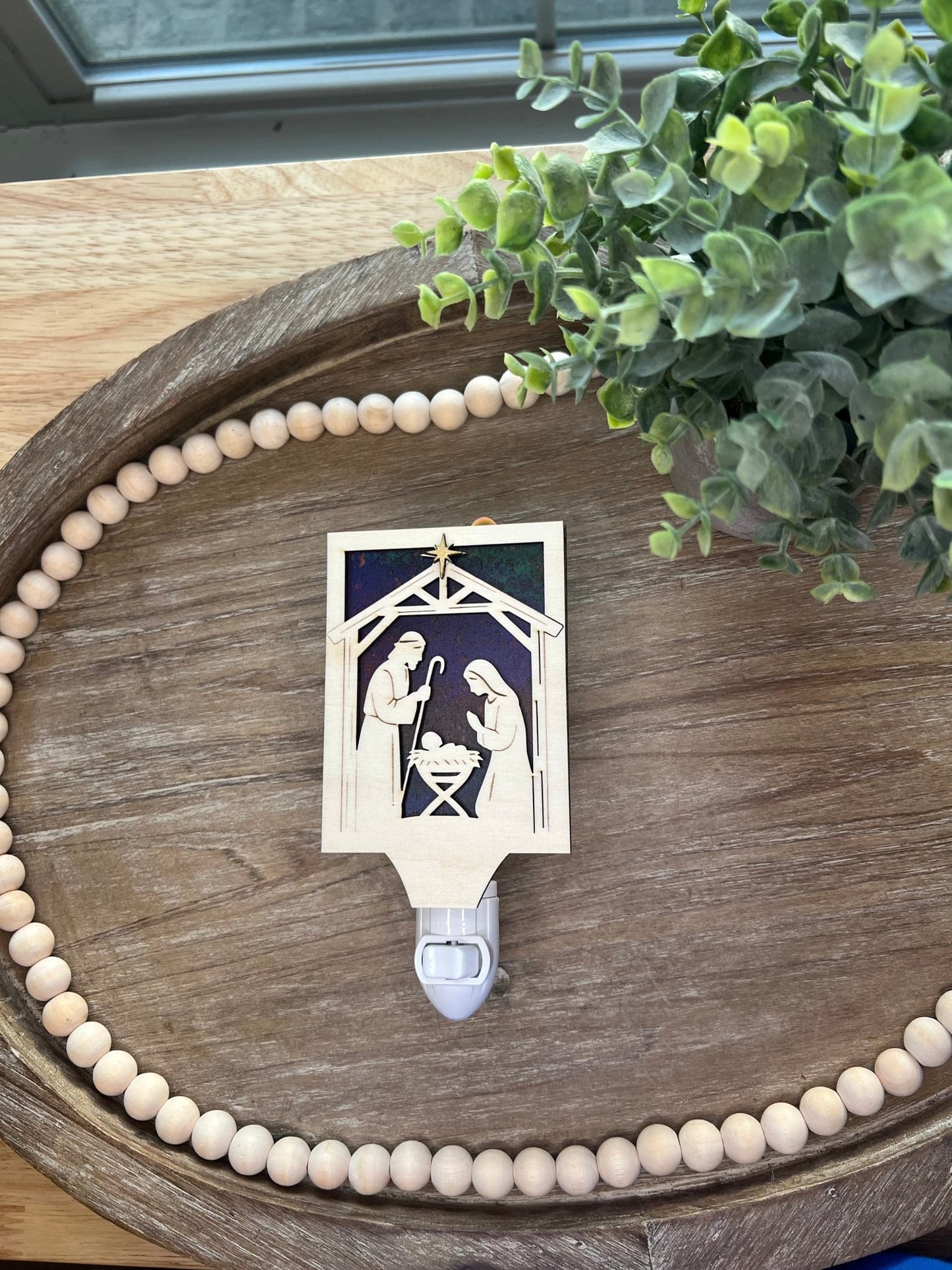 Christmas Nativity Nightlight made of wood and acrylic, featuring natural wood and multicolor elements lying on a tray.