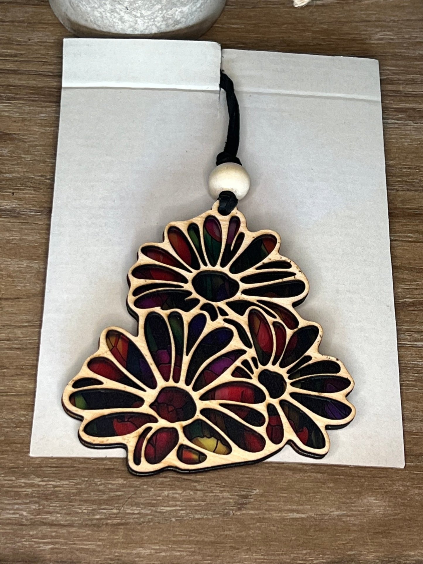 Daisy-shaped suncatcher with stained glass effect in wood and acrylic.