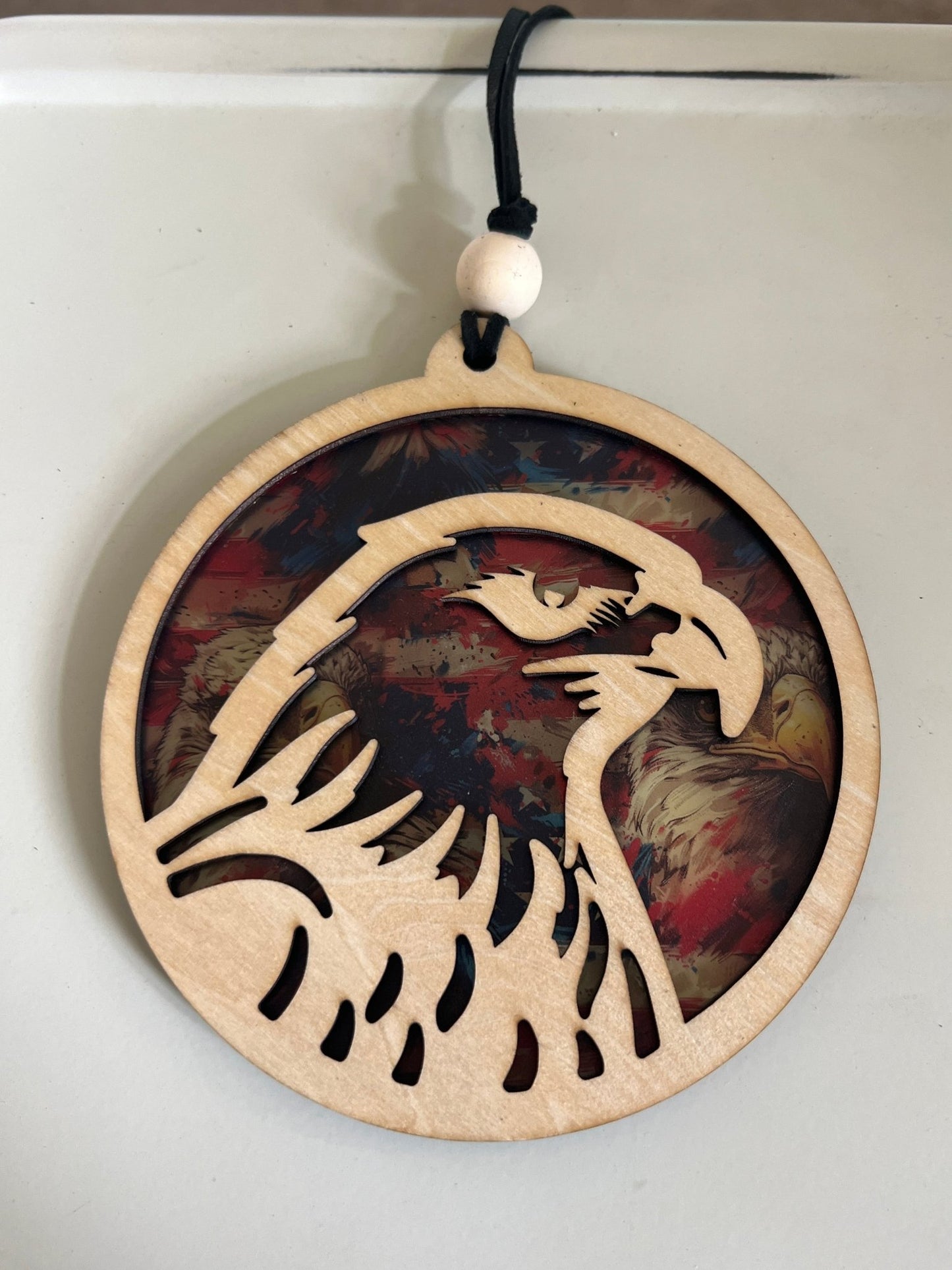 Eagle-shaped suncatcher with natural wood and multicolor acrylic, capturing light beautifully.