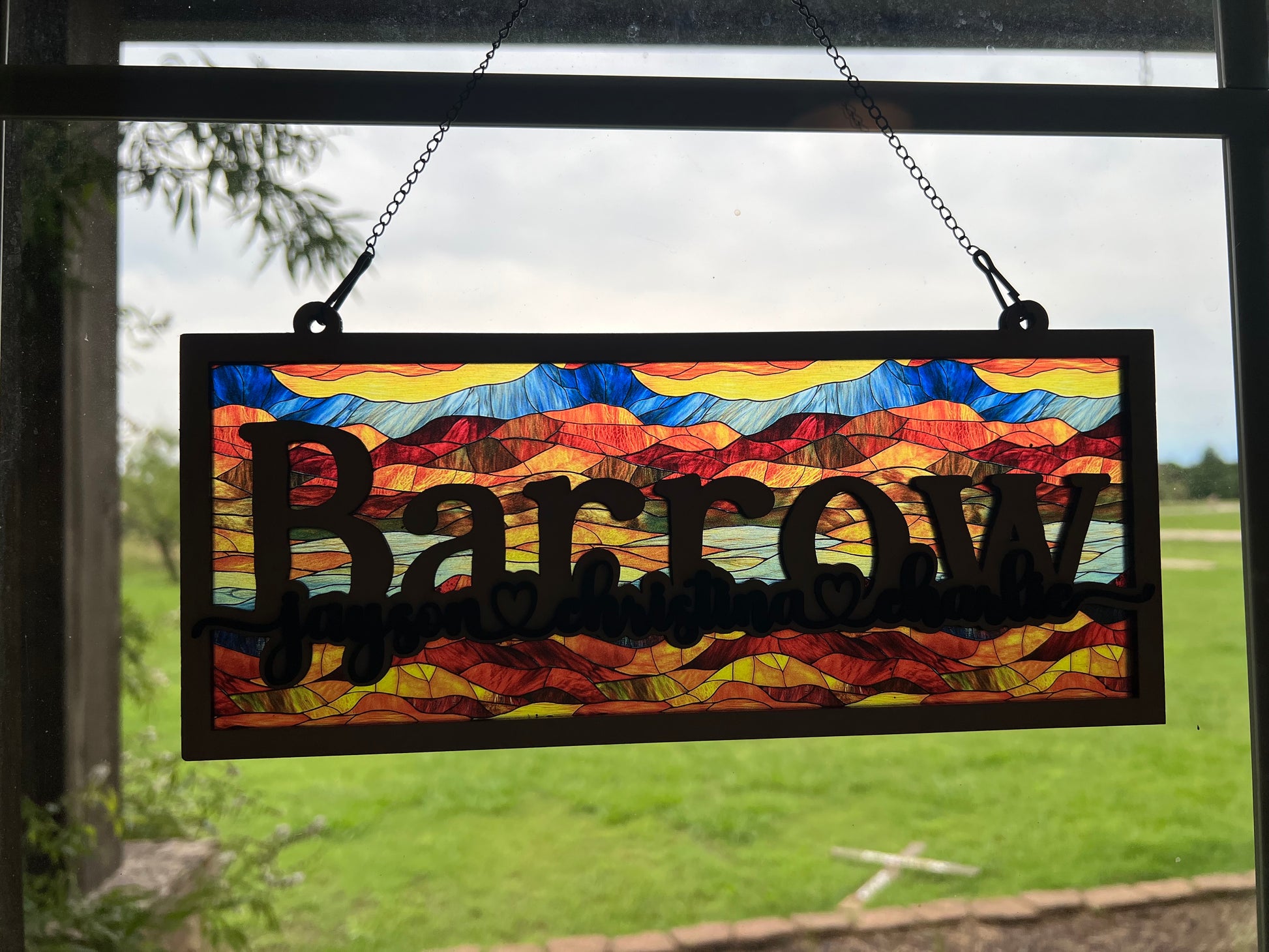 Family Personalized Suncatcher in natural wood and multicolor acrylic, showcasing rustic-modern style in sunlight.