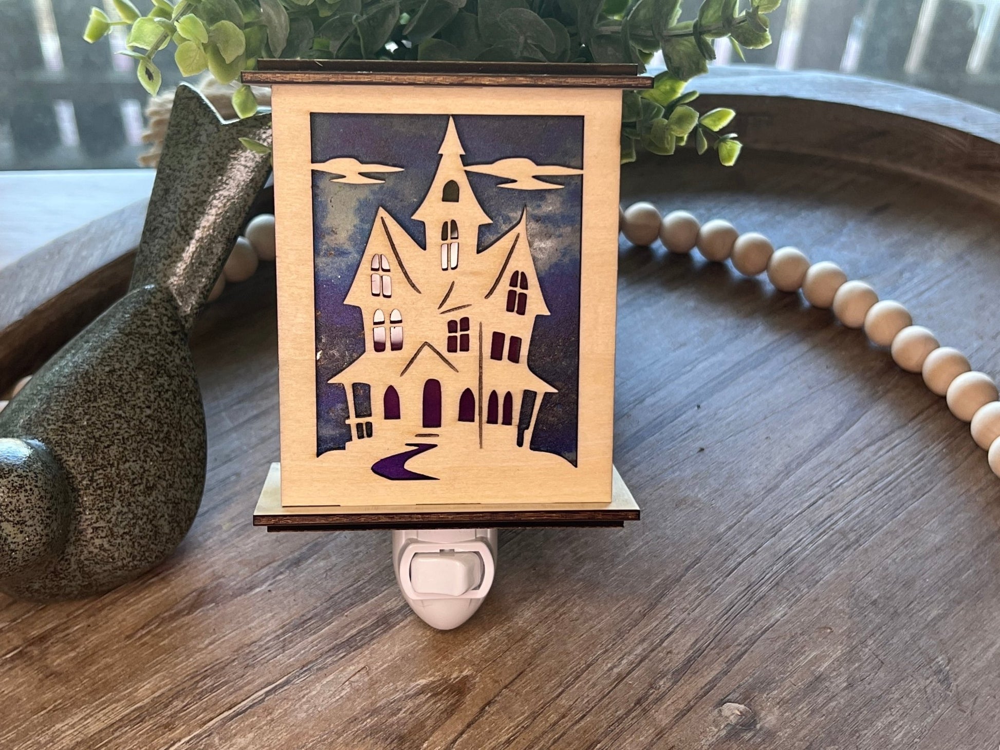 Halloween Haunted House Lantern Nightlight made from wood and acrylic, showcasing rustic charm and multicolor glow in natural light.