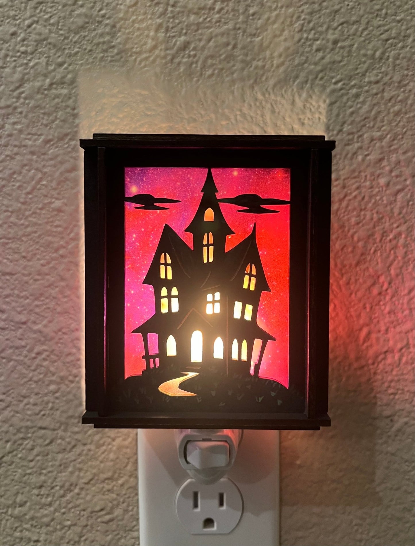 A haunted house hand painted stained glass effect nightlight, multicolor acrylic and black wood design - lit view.