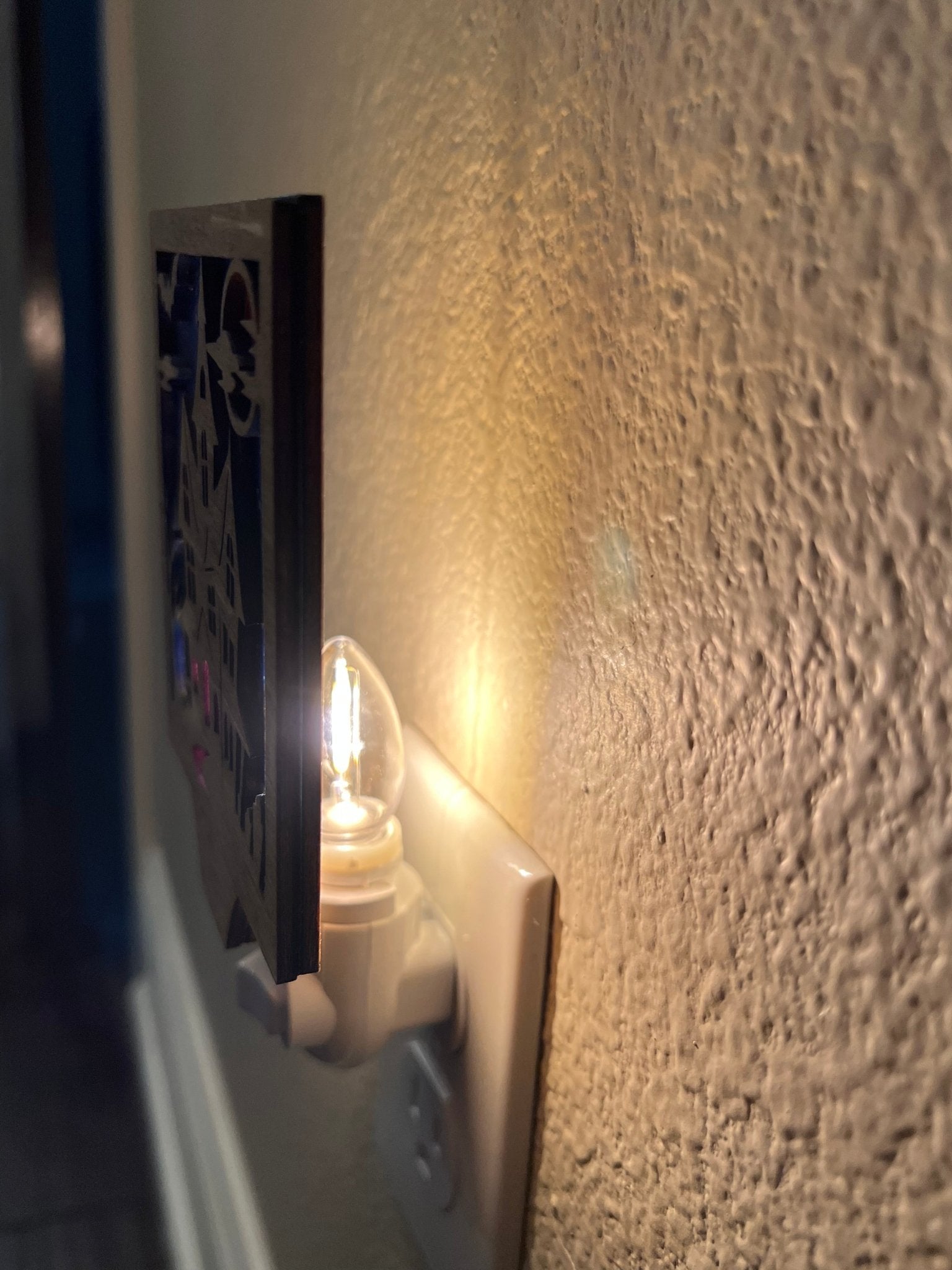 Haunted House Nightlight made of wood and acrylic, golden oak stained, rustic decor, side view and plugged in.