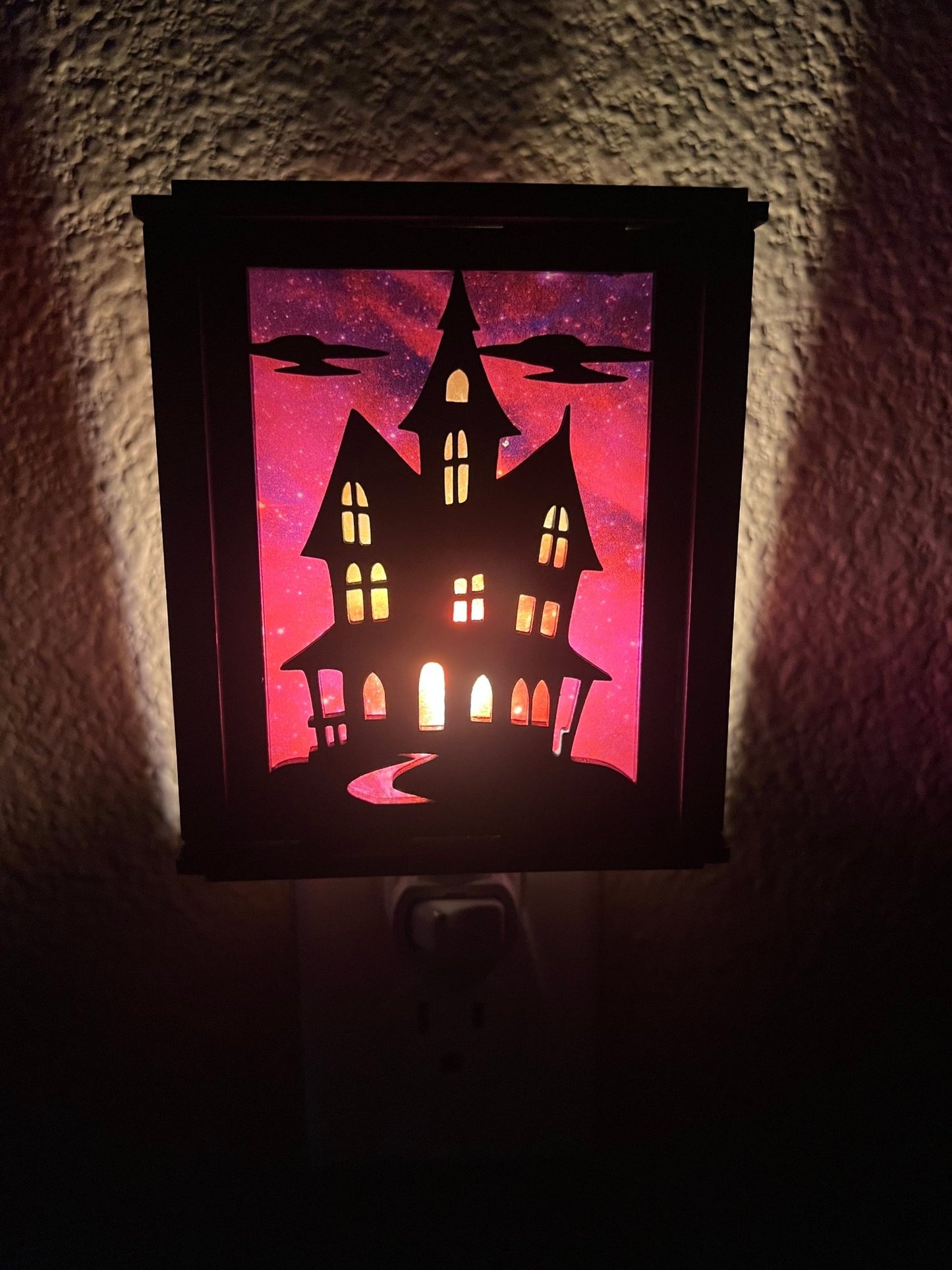 Black wooden haunted house nightlight with multicolor acrylic accents - front lit view.