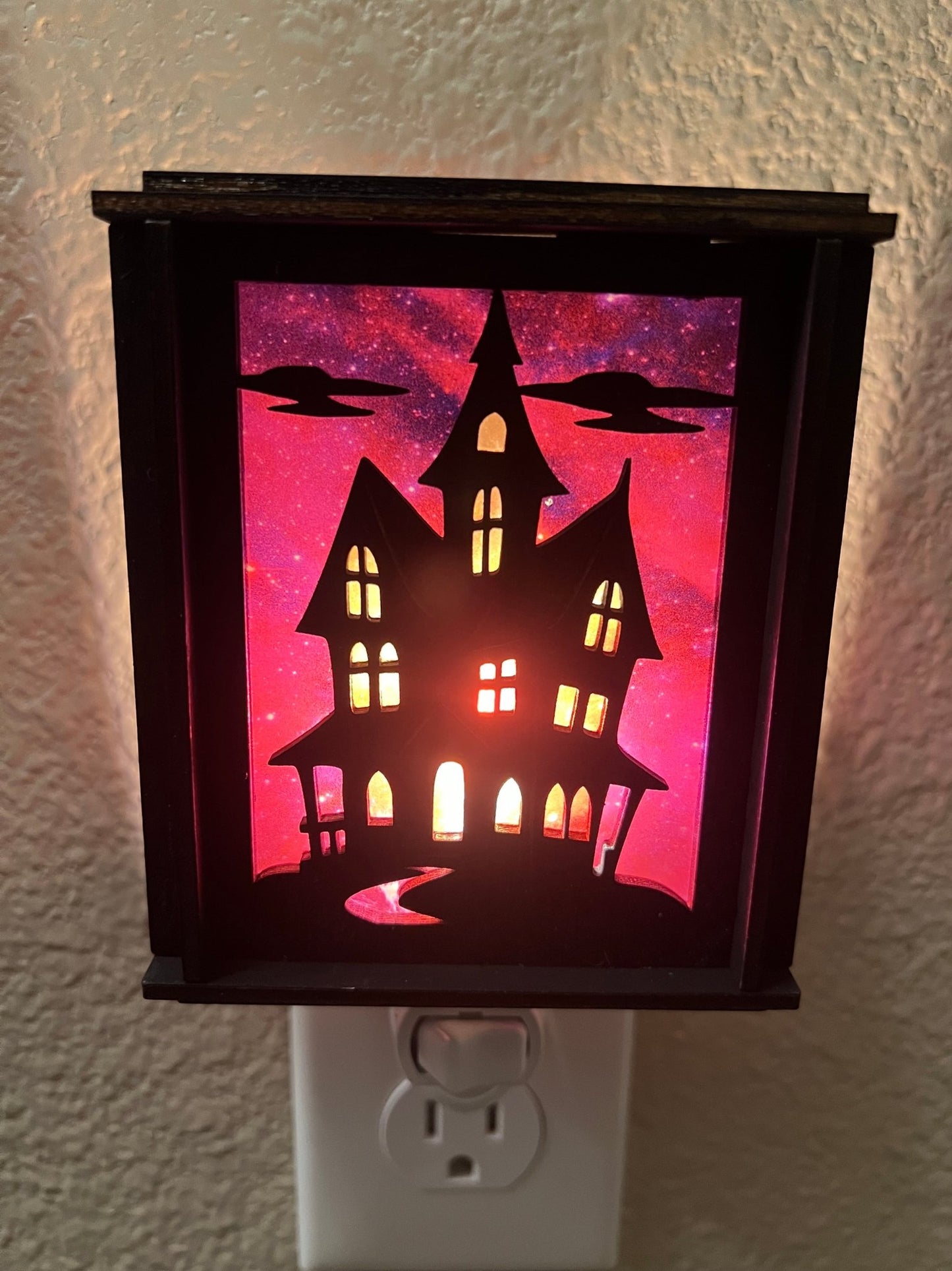 Black wooden haunted house nightlight with multicolor acrylic accents - front lit.