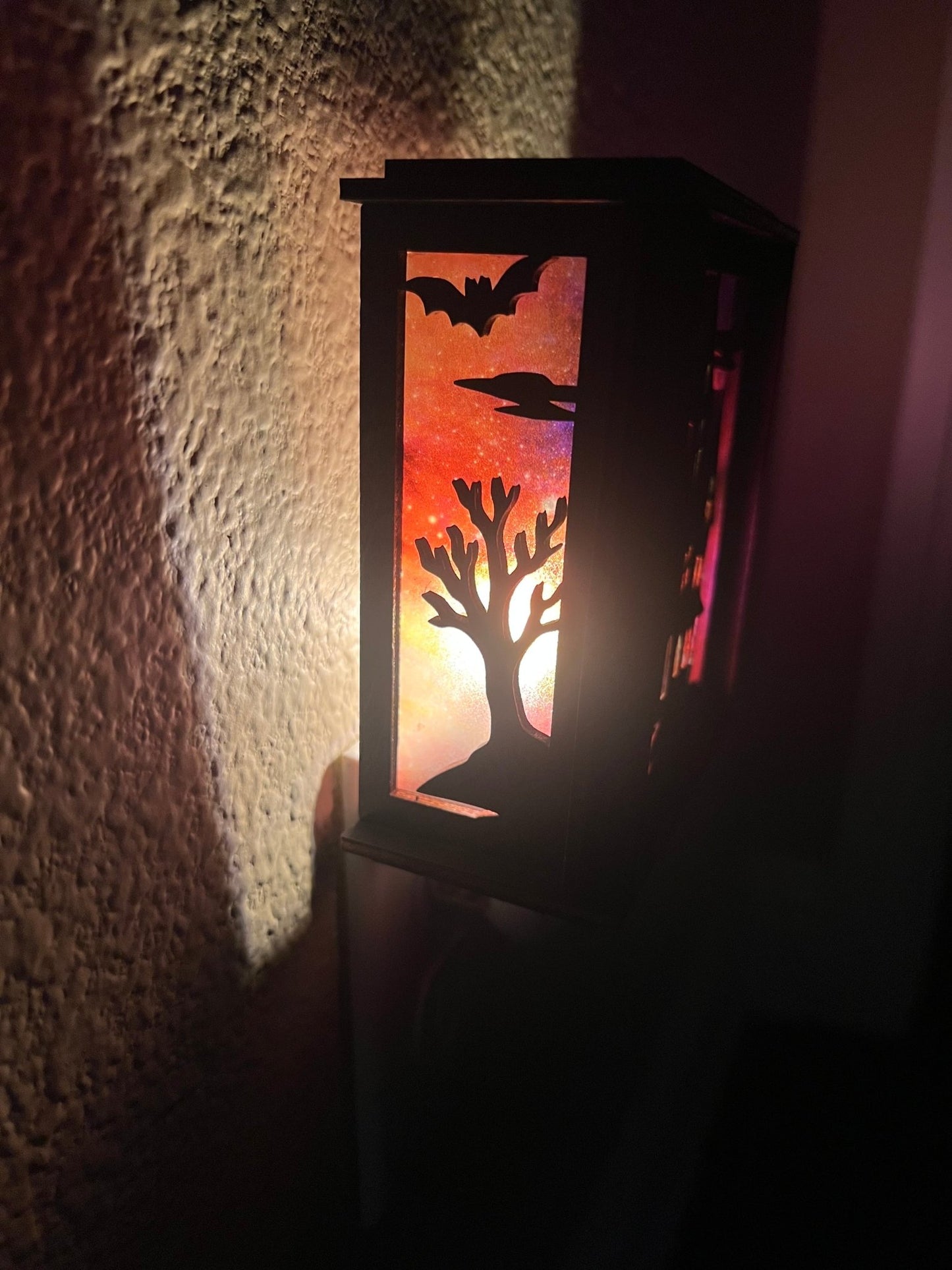 Black wooden haunted house nightlight with multicolor acrylic accents left side lit.