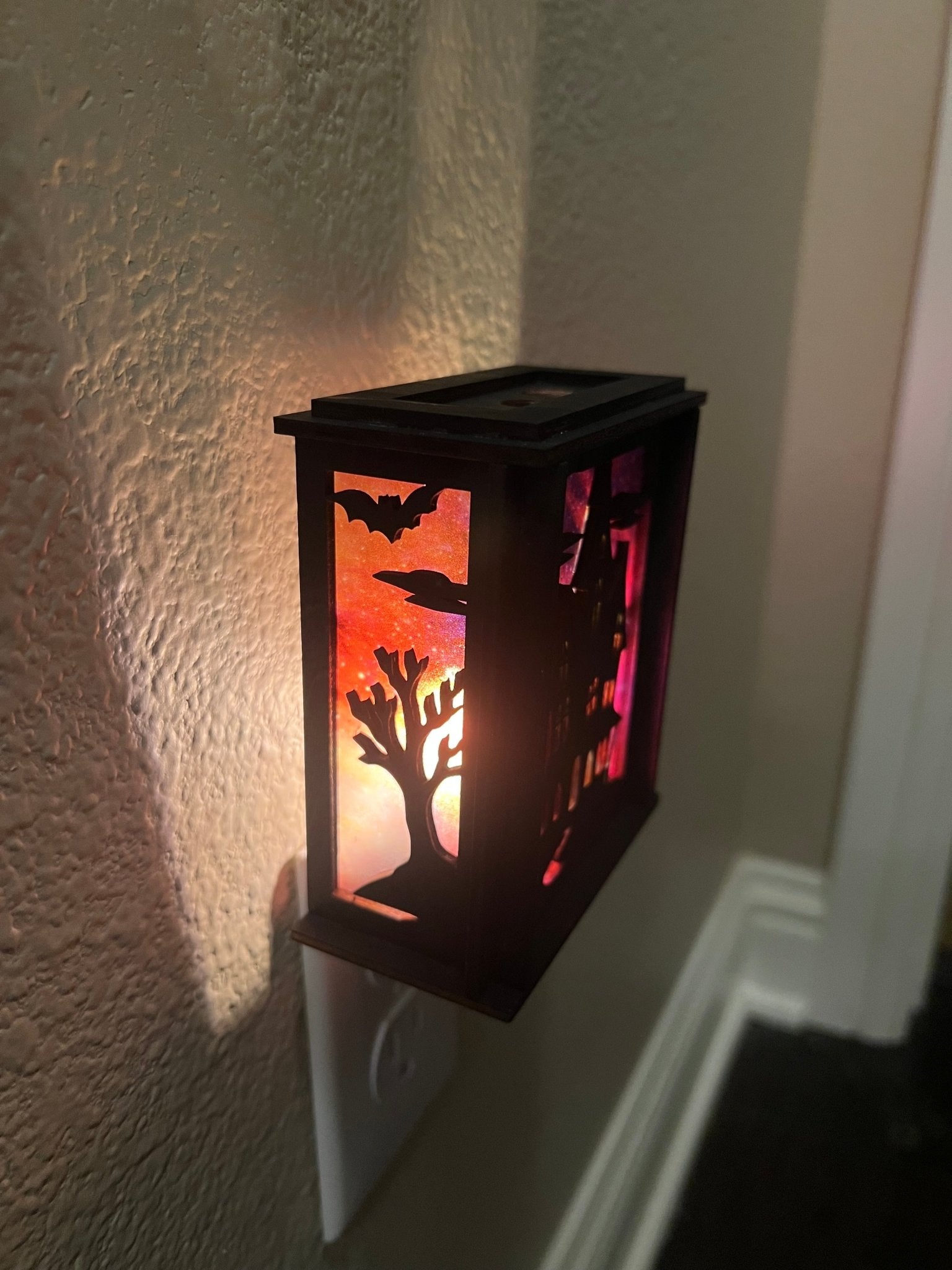 Black wooden haunted house nightlight with multicolor acrylic accents - left side lit.