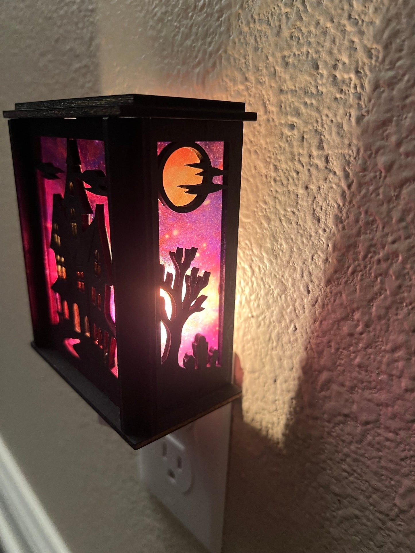 Black wooden haunted house nightlight with multicolor acrylic accents right side lit.