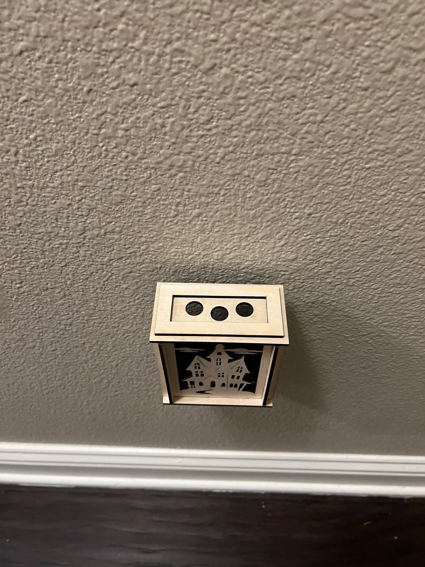 A haunted house-themed suncatcher with stained glass effect in black and multicolor acrylic - from top.