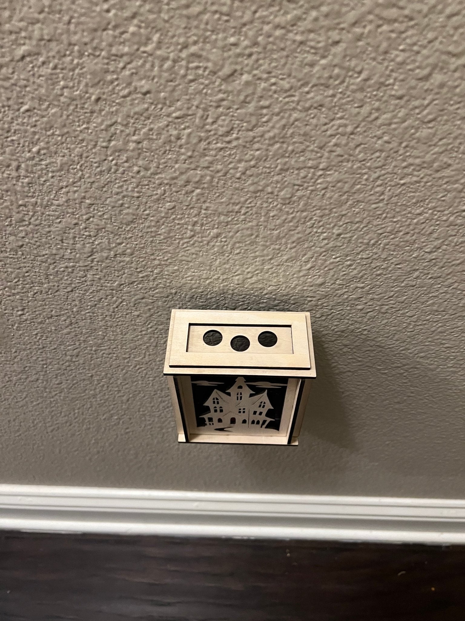 A haunted house-themed suncatcher with stained glass effect in black and multicolor acrylic - from top.