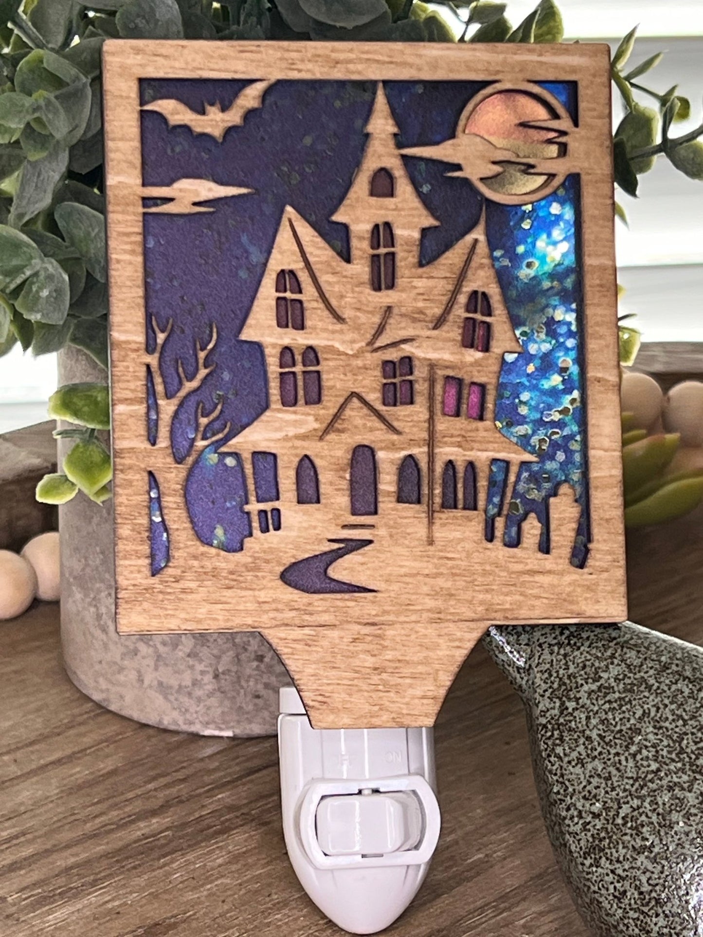 Haunted House Nightlight made of wood and acrylic, golden oak stained, rustic decor, front facing in sunlight..