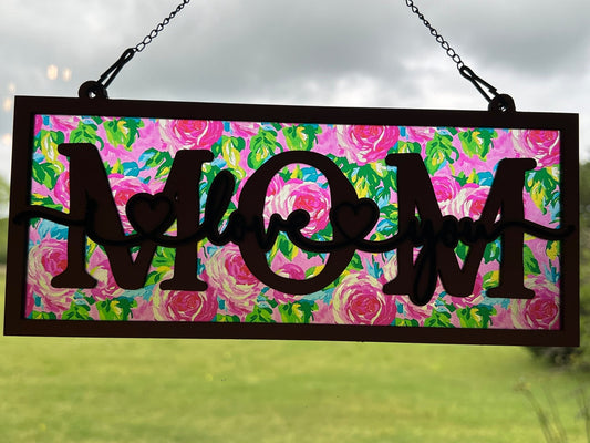 Beautiful mom suncatcher with pink floral design in wood and acrylic, 4.25 x 9.5 inches in sunlight.