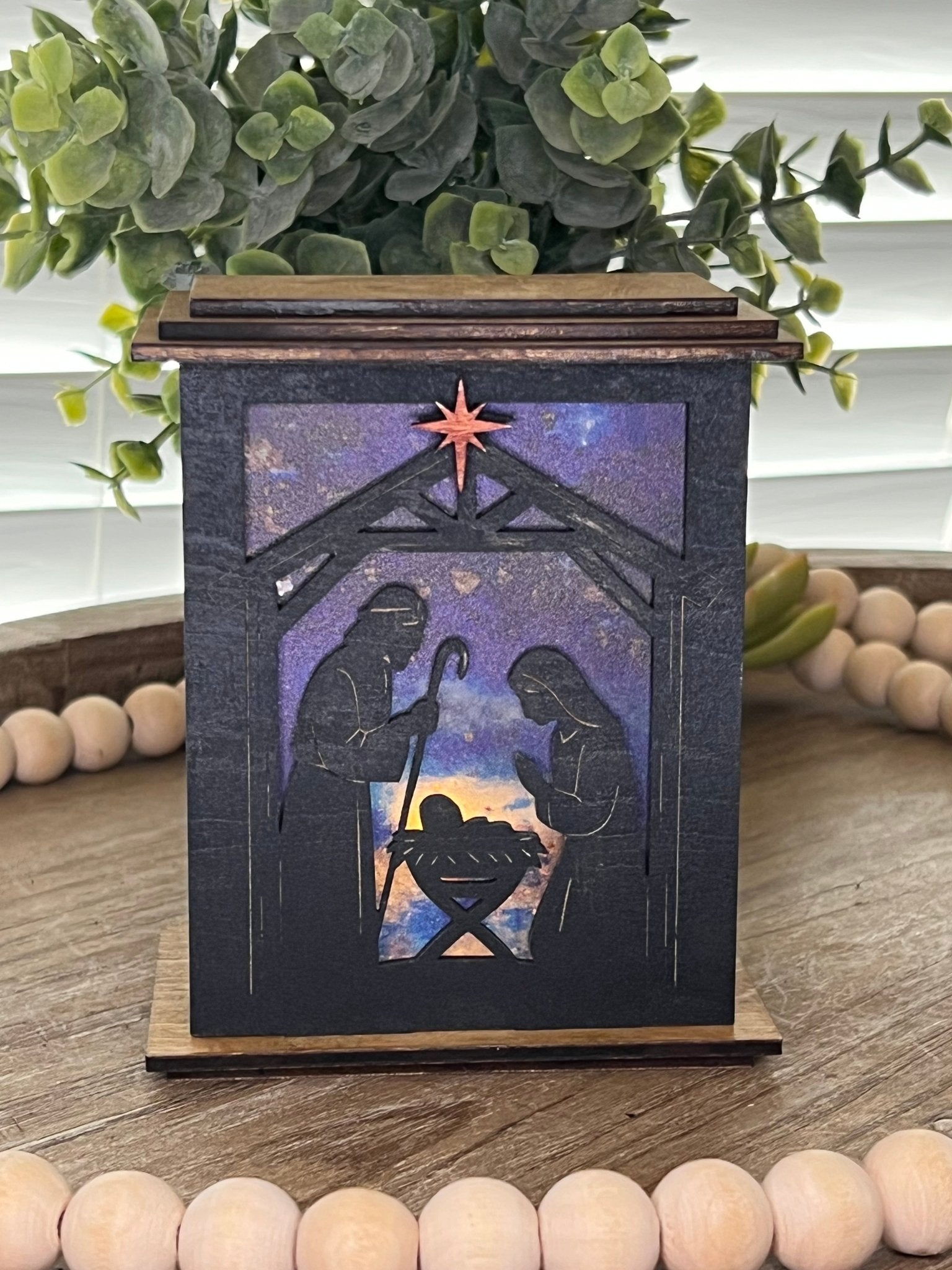 Rustic black and golden oak nativity lantern with LED tea-light candle, perfect for holiday decor, front, lit view