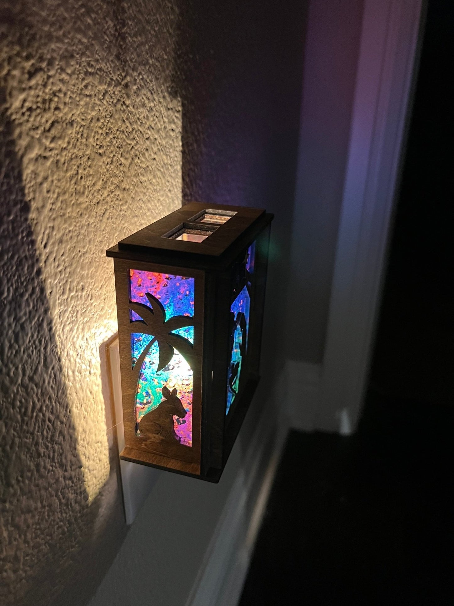 Golden oak stained wooden and acrylic nativity nightlight with rustic charm left view plugged in and lit.