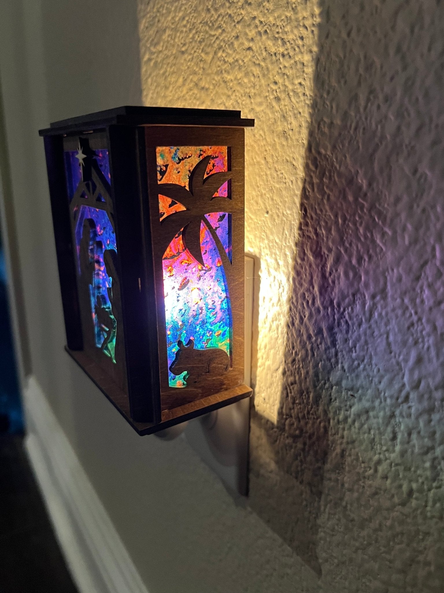 Golden oak stained wooden and acrylic nativity nightlight with rustic charm right view plugged in and lit.