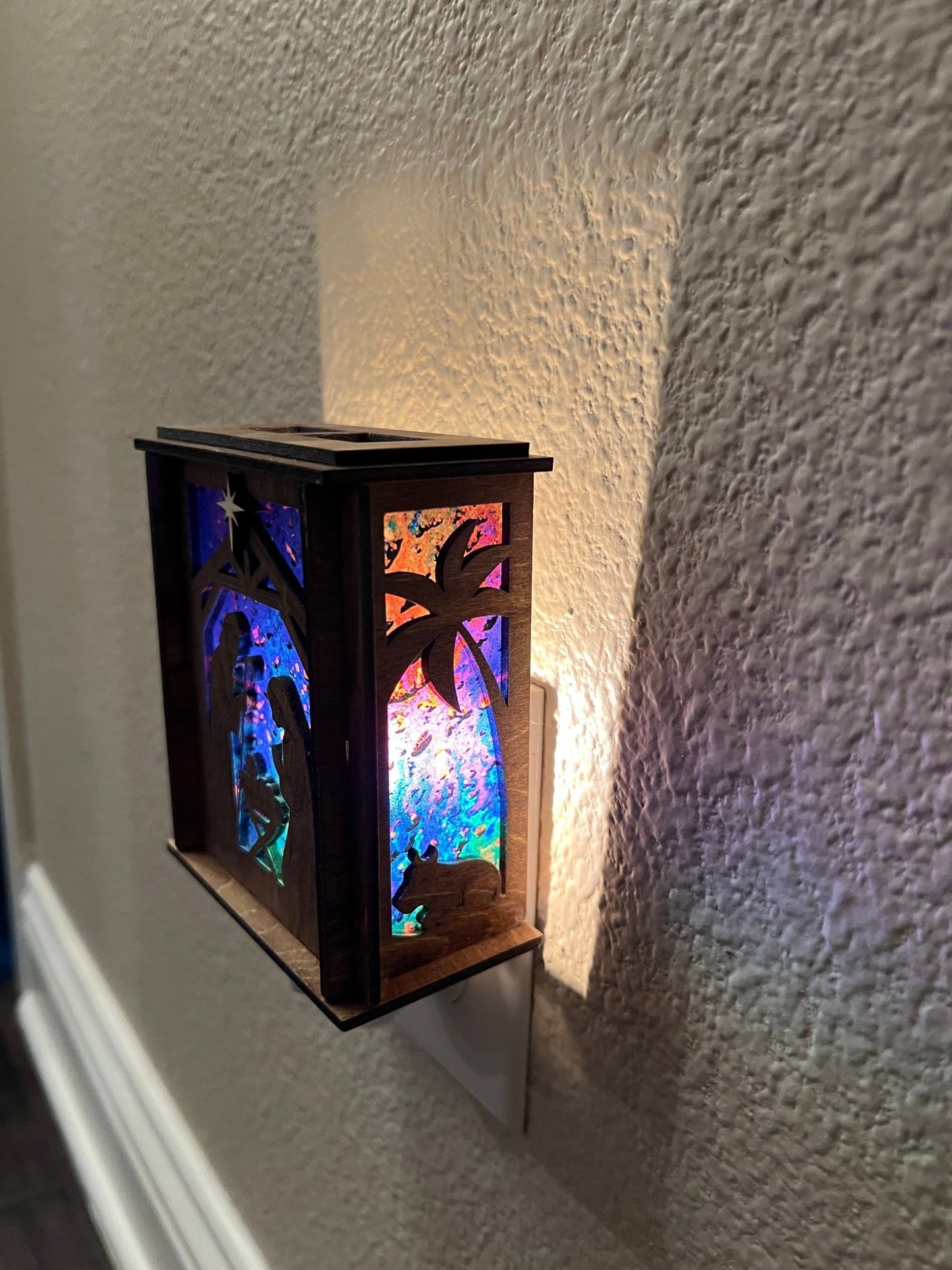 Golden oak stained wooden and acrylic nativity nightlight with rustic charm right  view plugged in lit.