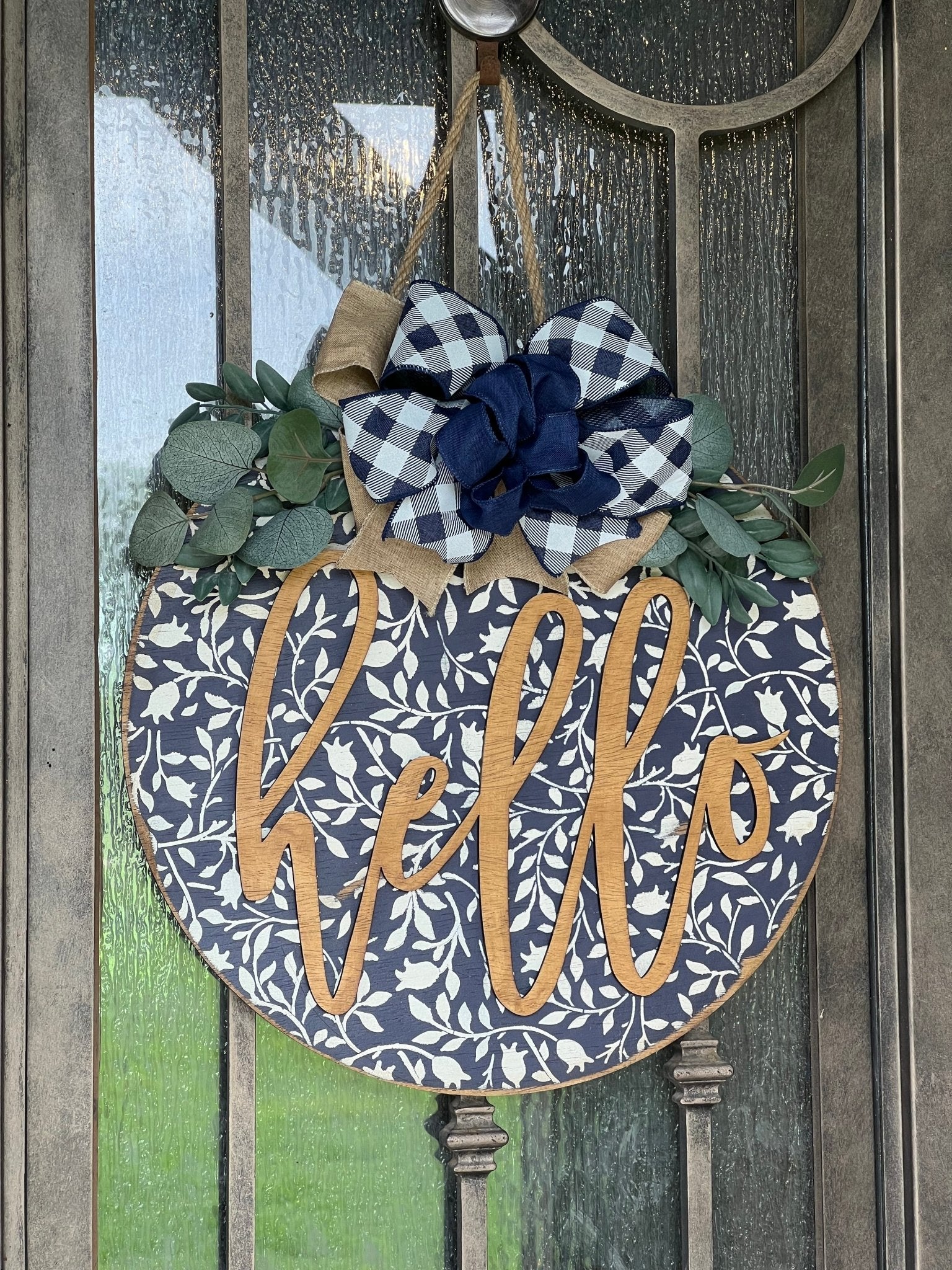 Navy wood hello door hanger with mini flowers on metal door, perfect for rustic entryway decor.