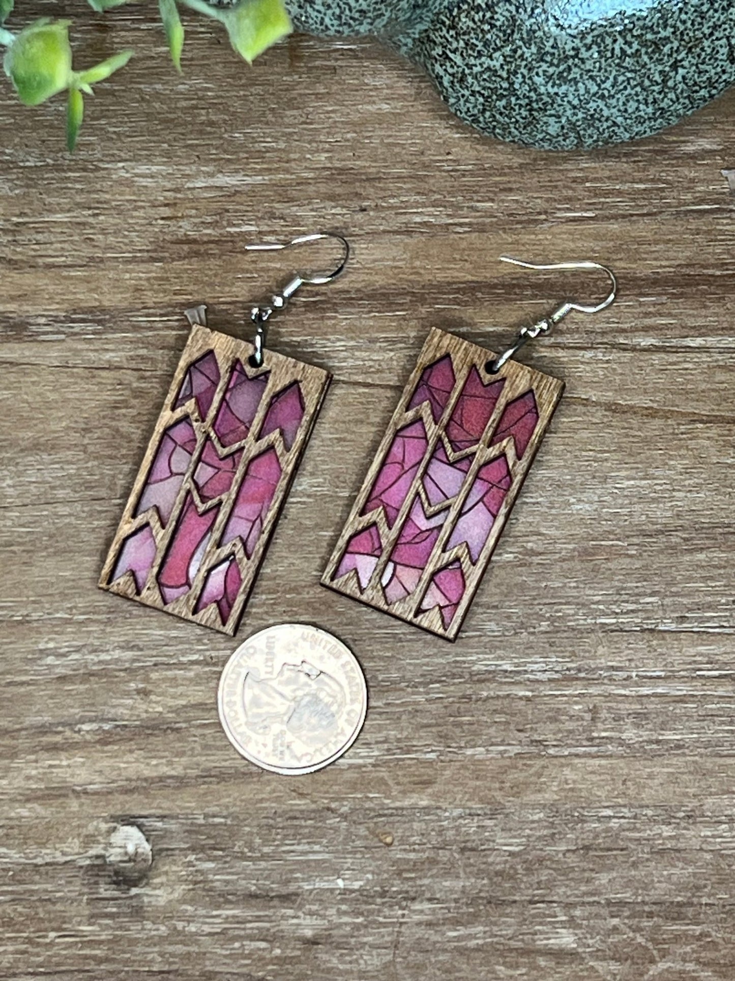 Pink butterfly earrings made from wood and acrylic with a stained glass effect.