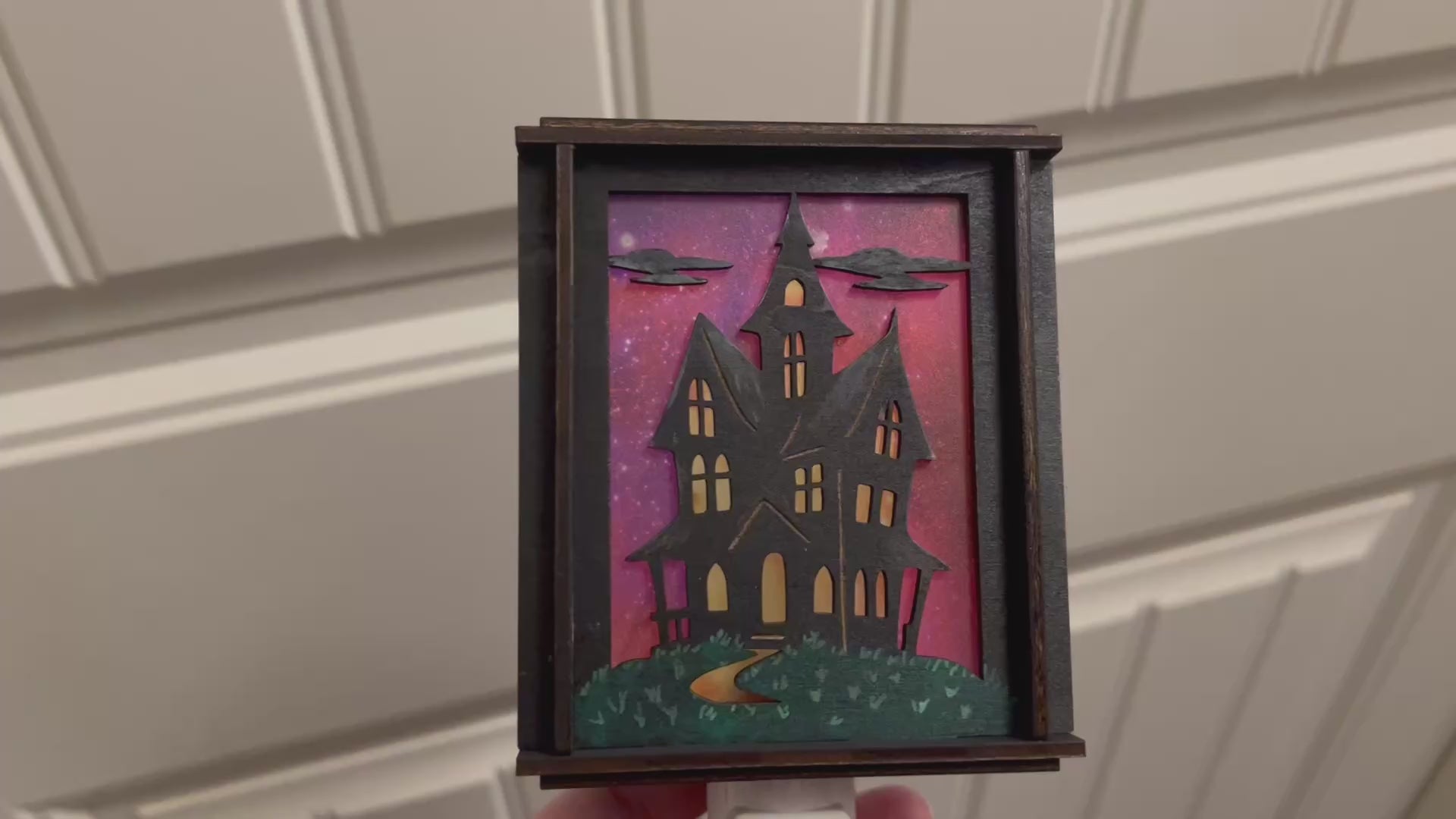 Video of a  haunted house hand painted stained glass effect nightlight, multicolor acrylic and black wood design.