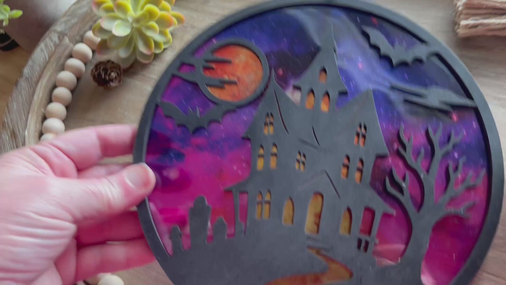 Hand painted suncatcher with a haunted house design on wood and acrylic, in vibrant colors - unlit back view video.